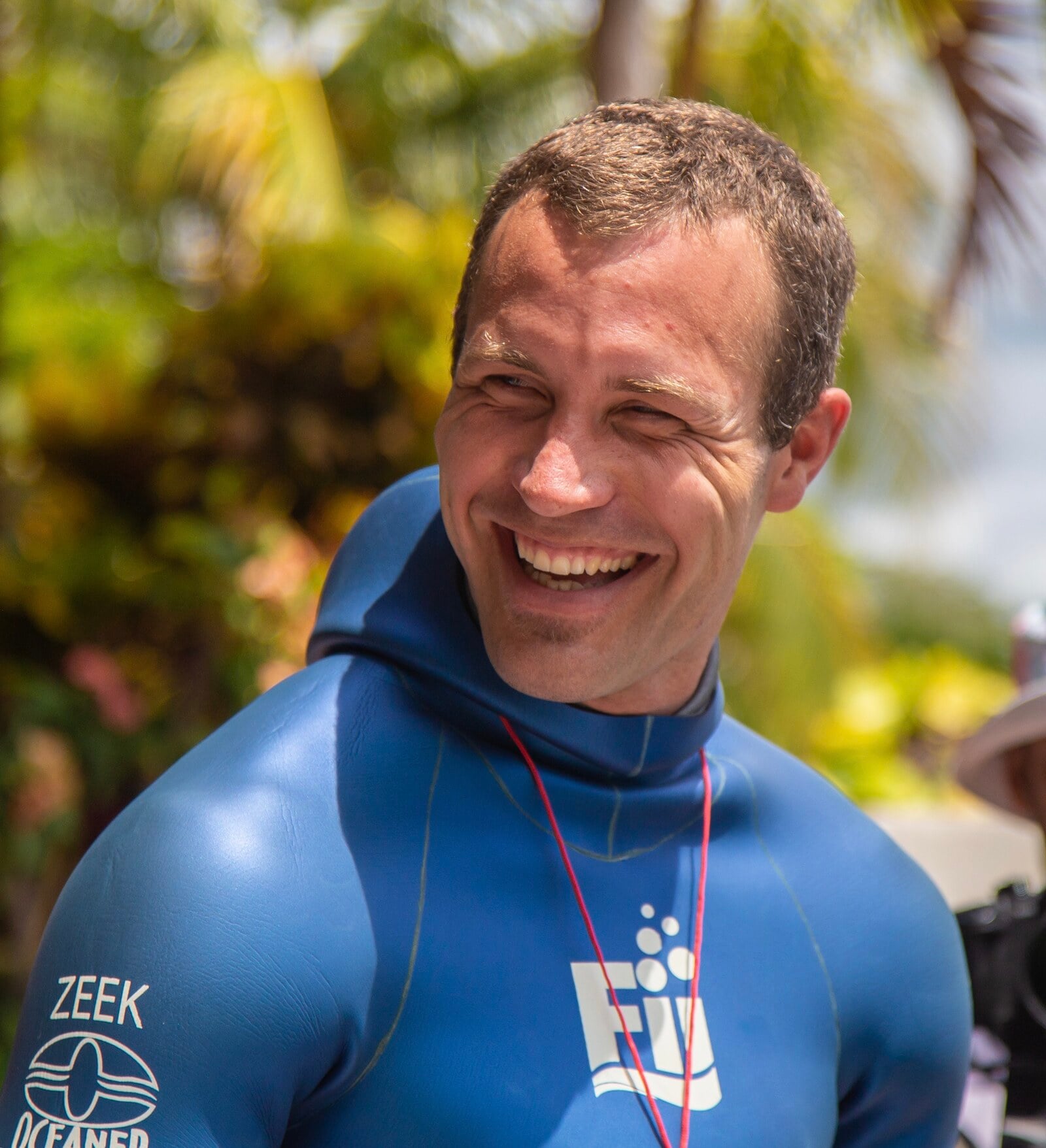 Brandon Zeek laughing his FII wetsuit under the palms