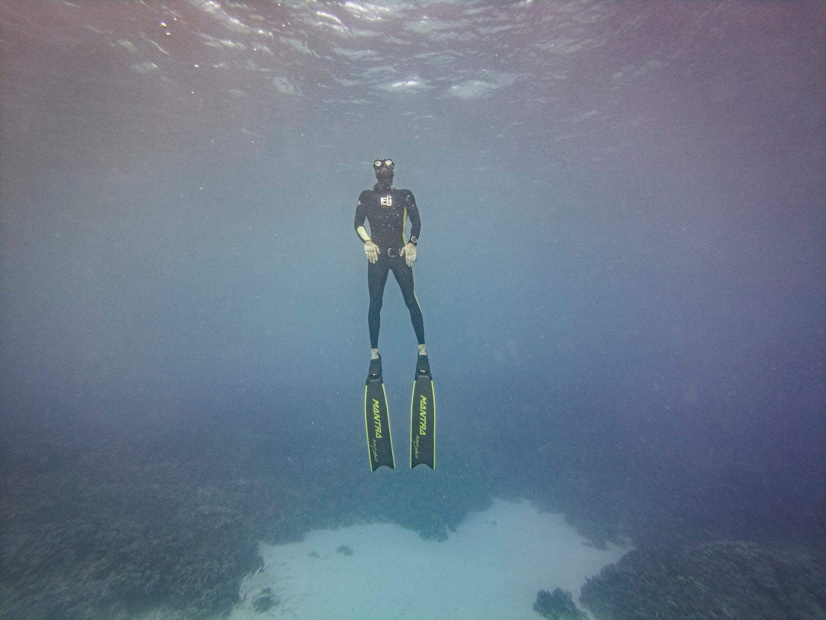 A freediver ascending the line toward the light